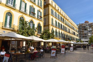 Malaga 'daki şehir plajı, arka planda doğa ve dağlarla rahatlayan insanlar, İspanya