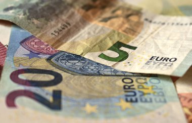 Beş avro ve yirmi avroluk avroluk banknot, arka plan olarak karışık banknotlar, yakın plan