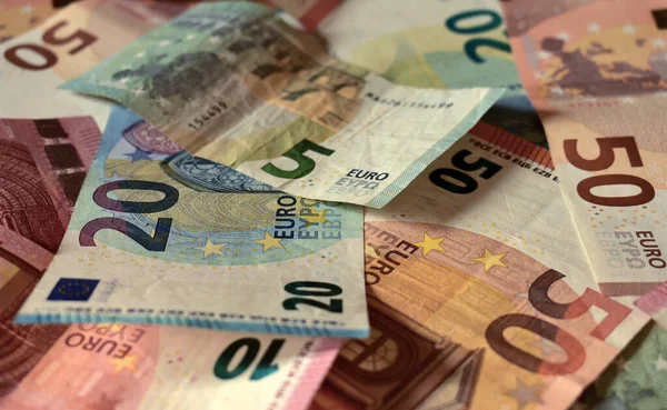 Scattered euro banknotes in denominations of five euros, ten euros, twenty euros, fifty euros, mixed banknotes as background, close-up