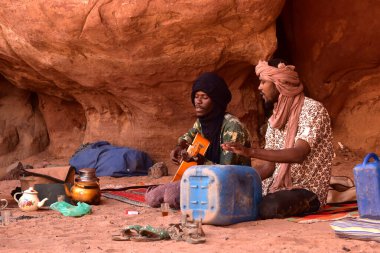 Genç Tuareg erkekleri gitar çalıyor ve davul, Djanet, Sahara, Cezayir, Afrika 'nın yerini boş bir teneke kutu alıyor.