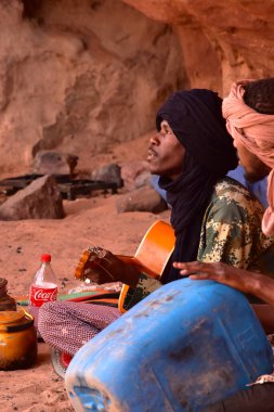 Genç Tuareg erkekleri gitar çalıyor ve davul, Djanet, Sahara, Cezayir, Afrika 'nın yerini boş bir teneke kutu alıyor.