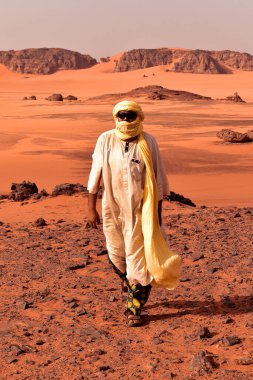 Djanet, Sahara, Cezayir - 4 Mayıs 2023: Tuareg, Sahra Çölü 'nün yerel rehberi, arka planda kum tepeleri ve dağlarla.