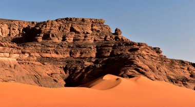 Tadrart Rouge 'da kaya oluşumları, Tassili N' Ajjer Ulusal Parkı. Sahra çölü, kum tepeleri, turuncu kum ve kayalar. Tatiller ve Cezayir 'de seyahat. Sahra, Cezayir, Afrika.