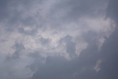 Birkaç gri gölgesi olan bulutlu bir gökyüzü tüm manzarayı kaplayan yoğun bulutları gösteriyor. Bu da gizli bir hava durumunu gösteriyor. Görünür bir güneş veya açık alan yok.