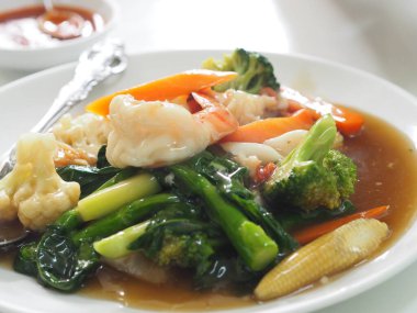 Tayland usulü yengeç omleti, beyaz tabakta yumurta sarısı yemek.