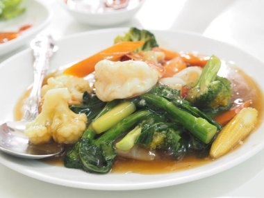 Tayland usulü yengeç omleti, beyaz tabakta yumurta sarısı yemek.