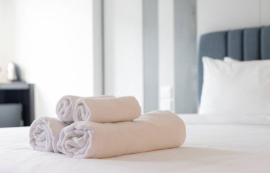 Temiz ve Düzenli Otel Yatak Odası: Temiz, Yumuşak Çarşaflı Beyaz Yatak, Katlanmış Havlular ve Rahat Yastıklar, Temiz ve Rahatlatıcı Atmosfer Oluşturma