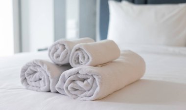 Temiz ve Düzenli Otel Yatak Odası: Temiz, Yumuşak Çarşaflı Beyaz Yatak, Katlanmış Havlular ve Rahat Yastıklar, Temiz ve Rahatlatıcı Atmosfer Oluşturma