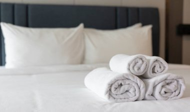 Temiz ve Düzenli Otel Yatak Odası: Temiz, Yumuşak Çarşaflı Beyaz Yatak, Katlanmış Havlular ve Rahat Yastıklar, Temiz ve Rahatlatıcı Atmosfer Oluşturma