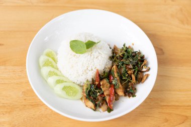 Lezzetli bir tabak kızarmış pirinçli tavuk ve fesleğenli kızarmış sebze ve otlar, Asya mutfağını sergilemek için mükemmel..