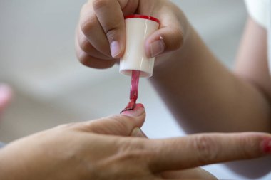 Anne-kız tırnak boyama seansı pembe cilalı, kendine bakım salonu kadın tırnak teknisyeni, tırnak sanatı parlatıcısı, süsleme, yaratıcılık güzellik eller, anne ve çocuk manikür tedavisi.