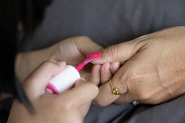 Anne-kız tırnak boyama seansı pembe cilalı, kendine bakım salonu kadın tırnak teknisyeni, tırnak sanatı parlatıcısı, süsleme, yaratıcılık güzellik eller, anne ve çocuk manikür tedavisi.