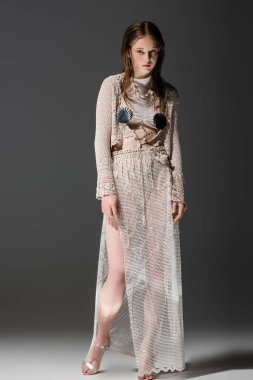 Örgü hırka ve gri arka planda file etekli şık bir denizkızı. 