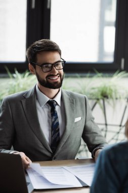 Pozitif yönetici iş görüşmesinde bulanık kadın ve dizüstü bilgisayarın yanında özgeçmiş tutuyor 