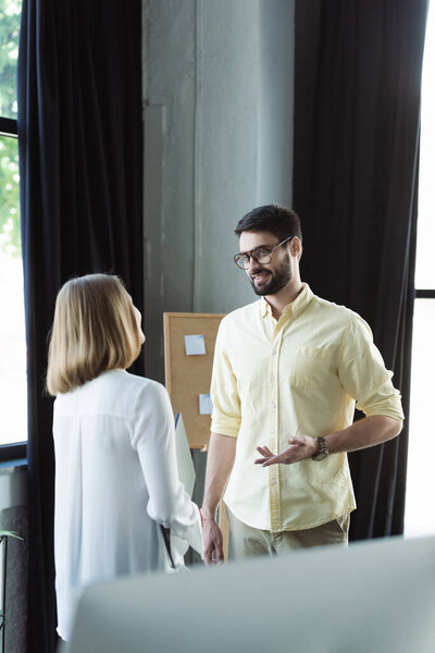 Бизнесмен беседует с молодым коллегой с ноутбуком во время стажировки в офисе 