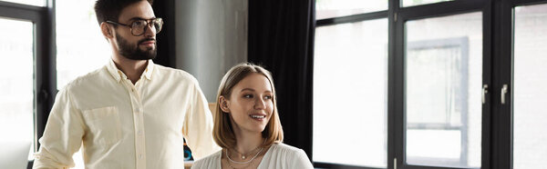 Businessman and intern looking away in office, banner 