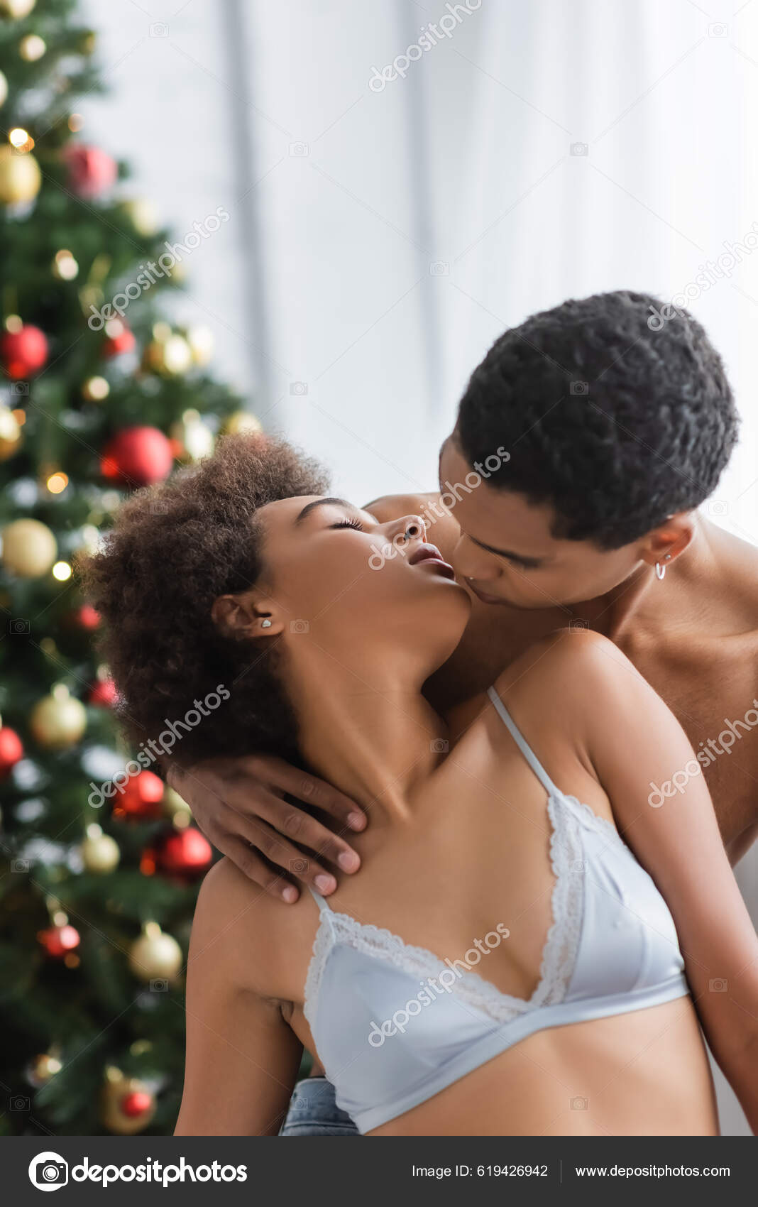 Shirtless African American Man Kissing Young Sexy Girlfriend Blurred Christmas — Stock Photo © HayDmitriy #619426942