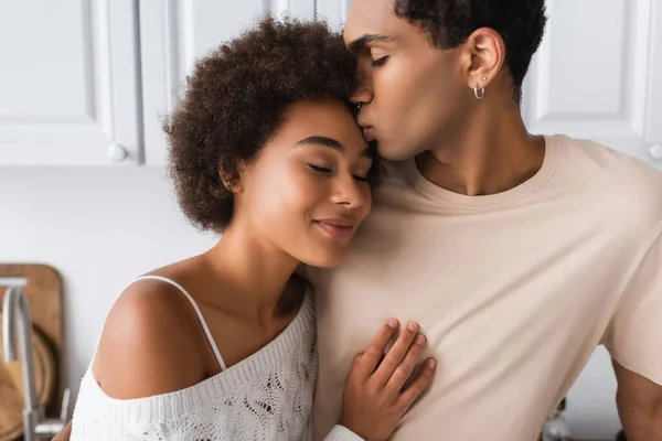 Νεαρός Αφροαμερικάνος Φιλάει Χαμογελαστή Φιλενάδα Στέκεται Κλειστά Μάτια Στην Κουζίνα — Φωτογραφία Αρχείου