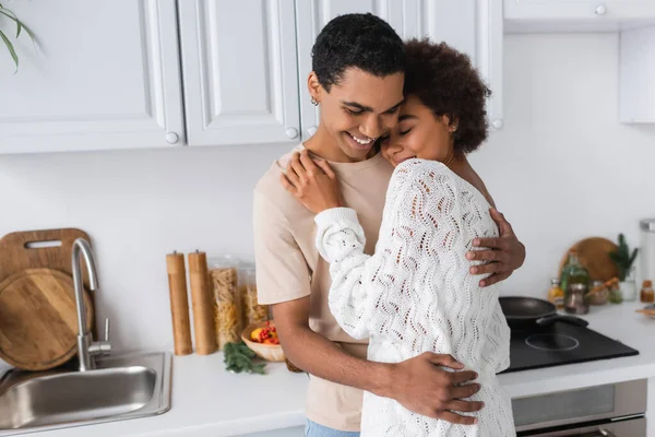 Pasangan African American Ceria Berpelukan Dekat Meja Kerja Dapur — Stok Foto