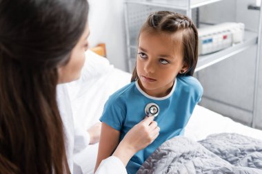 Yanık doktor, klinikte steteskoplu bir hastanın göğsünü kontrol ediyor. 
