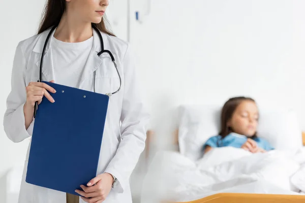 Pediatra Che Tiene Appunti Vicino Paziente Offuscato Nel Reparto Ospedaliero — Foto Stock