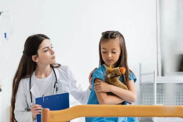 Pediatra Segurando Prancheta Acalmando Criança Chateada Com Brinquedo Macio Enfermaria — Fotografia de Stock
