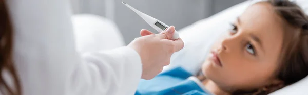 Arzt Hält Thermometer Neben Verschwommenem Kranken Kind Auf Krankenhausstation Transparent — Stockfoto