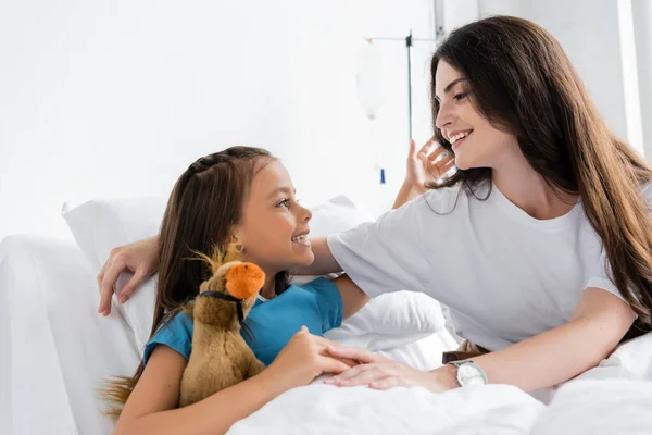 Позитивна Дитина Обіймає Матір Тримає Яку Іграшку Ліжку Клініці — стокове фото