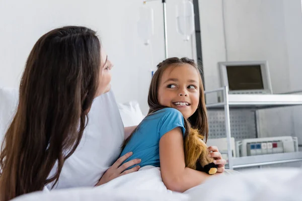 Madre Abrazando Feliz Hija Con Juguete Hospital Sala —  Fotos de Stock