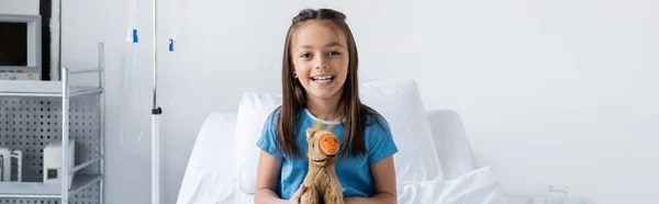 Cheerful Kid Holding Soft Toy Looking Camera Clinic Banner — Stock Photo, Image