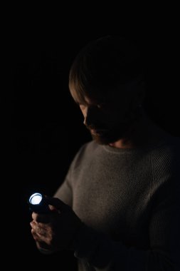 man holding glowing flashlight during power outage isolated on black clipart