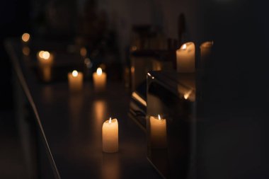 dark kitchen with candles burning on worktop during energy blackout clipart