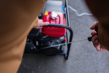 Enerji kesintisi nedeniyle elektrik jeneratörünü çalıştıran bulanık adamın kısmi görüntüsü