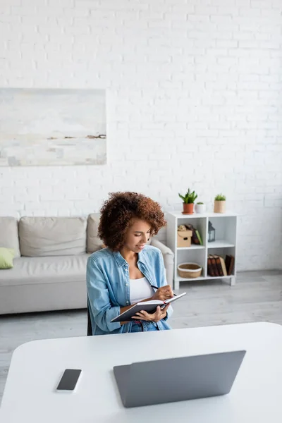 Curly African American Freelancer Writing Notebook Devices Living Room — Stock Photo, Image