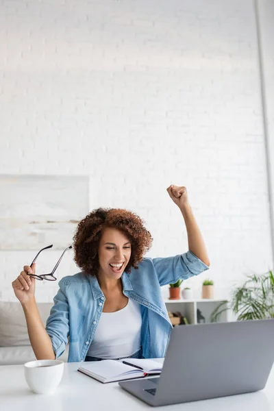 Excited African American Woman Holding Glasses Looking Laptop Table — Stock Photo, Image