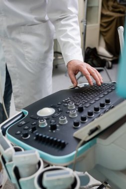  Beyaz önlüklü doktorun klinikteki ultrason cihazını ayarladığı görüntüler.