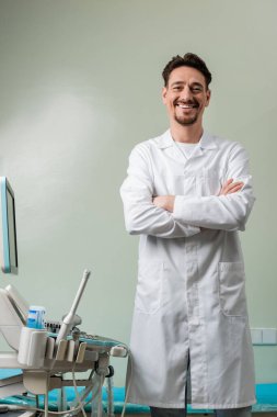 Modern ultrason makinesinin yanında duran neşeli doktor. 