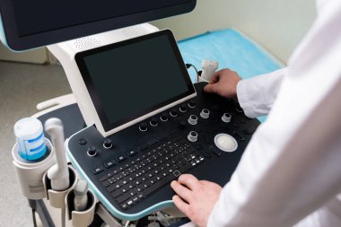 high angle view of modern ultrasound machine near cropped doctor clipart