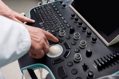 Ultrason makinesinin kontrol panelini kullanan hekimin kısmi görünümü