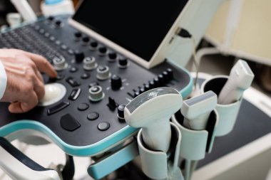 Hastanedeki ultrason makinesinin kontrol panelini kullanan doktorun kısmi görüntüsü