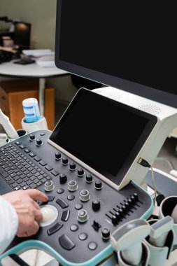 Doktorun büyük ekranlı modern ultrason makinesini çalıştırmasına kısmi bakış
