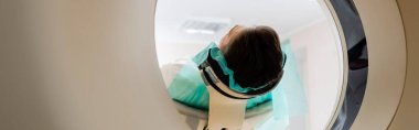 Yetişkin esmer adam klinikte bilgisayarlı tomografi tarayıcısı üzerinde tanı koyuyor.