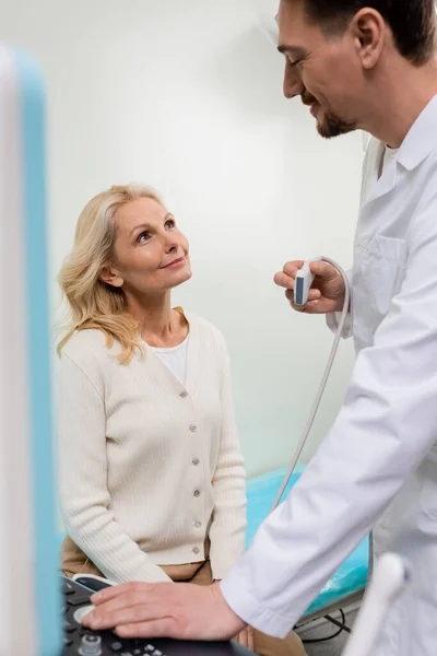 Szczęśliwy Lekarz Sondą Ultrasonograficzną Patrząc Szczęśliwą Blondynkę Szpitalu — Zdjęcie stockowe