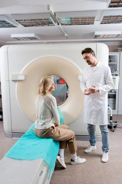 Full Length Radiologist White Coat Talking Blonde Woman Sitting Scanner — Stock Photo, Image