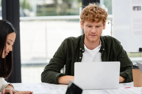 Young Redhead Businessman Working Laptop Asian Colleague — Stock Photo, Image