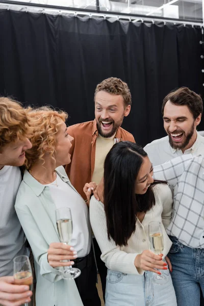 Excited Interracial Business People Holding Glasses Champagne Hugging Office — Stock Photo, Image