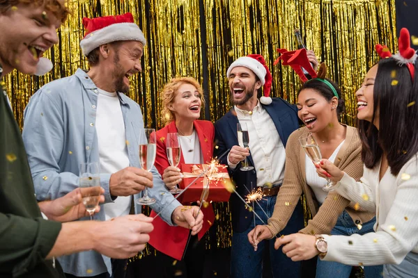 Nadšení Multietničtí Podnikatelé Držící Šampaňské Jiskry Během Vánočního Večírku Kanceláři — Stock fotografie