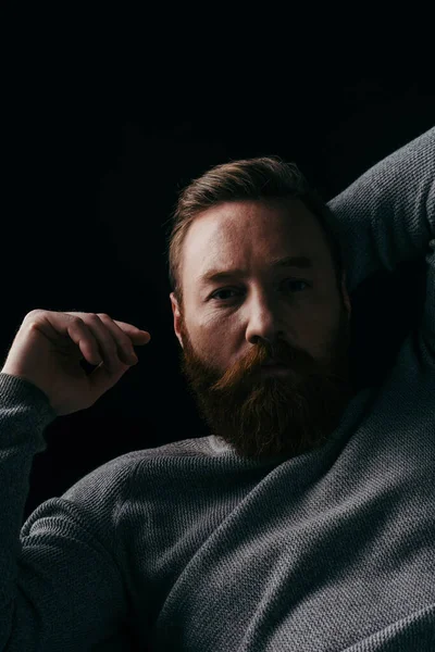 Портрет Бородатого Мужчины Сером Длинном Рукаве Позирующего Светлом Изолированном Черном — стоковое фото