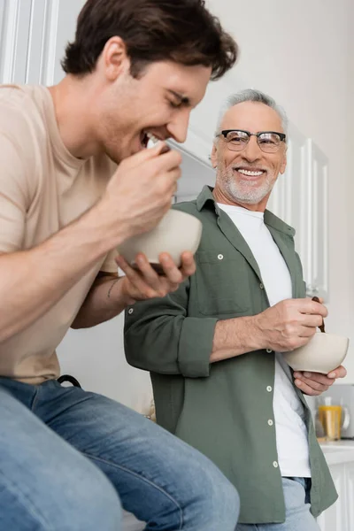 Hombre Feliz Anteojos Mirando Hijo Joven Desayunando Riendo Primer Plano —  Fotos de Stock
