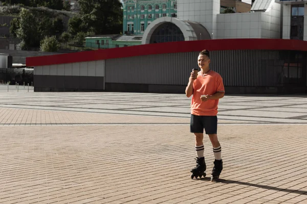 Aangename Rolschaatser Met Papieren Beker Mobiele Telefoon Tijdens Het Rijden — Stockfoto